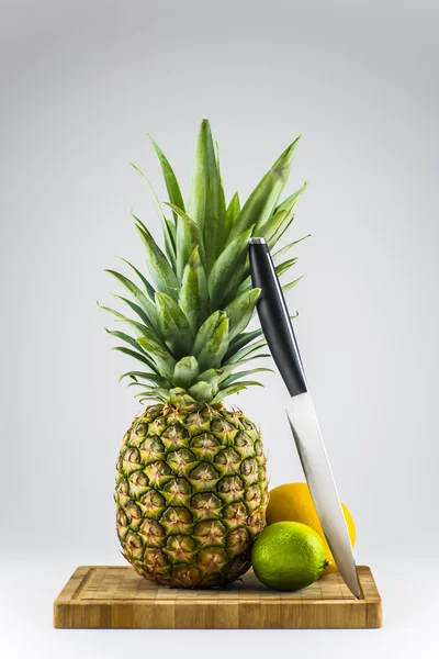 ananas, limon ve portakal bıçak ile kesme tahtası üzerinde