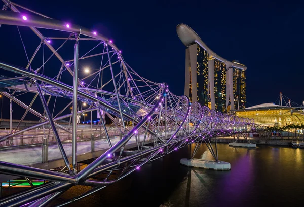 Singapur - 24 Mayıs: Helis Köprüsü ve marina bay sands 24 Nisan 2014. gece, ışıklar ziyaretçiler için özel bir görsel deneyim oluşturma bir dizi helix köprü yanar. — Stok fotoğraf