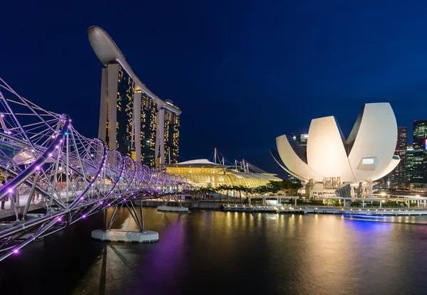 Singapore - 24 maj: helix bridge och marina bay sands på den 24 maj, 2014. på natten, är helix bron upplyst av en serie av ljus för att skapa en speciell visuell upplevelse för besökarna. — Stockfoto