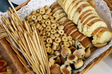 İçinde ekmek dilimleri, ekmek çubukları, taralli ve zeytinli sandviç olan bir sepet. Apulian yemekleri, fırın yemekleri.