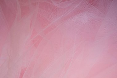 Pembe arka planda kıvrımları olan yumuşak, beyaz bir kumaş.