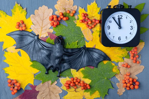 할로윈 밤 중간이었어. 핼러윈검은 박쥐와 다채 로운 나뭇잎 과 오렌지 열매를 배경으로 한 시계. 해피 할로윈 카드. 할로윈 축하 할 시간 — 스톡 사진