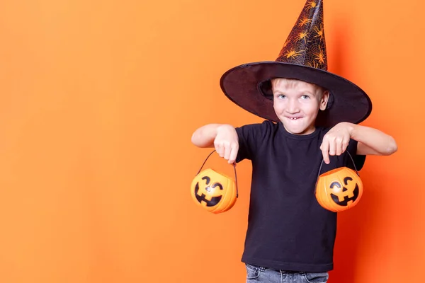 Joyeux seaux effrayants garçon avec des bonbons dans la lanterne de citrouille pour Halloween sur fond orange — Photo