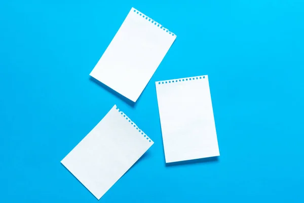 Белые чистые листы бумаги, вырванные из блокнота на ярко-синем фоне, место для текста. Scraps — стоковое фото