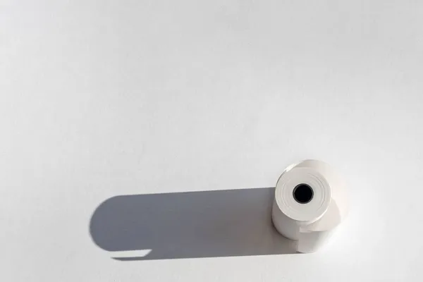 Kasettiteippirulla, jossa on varjo valkoisella paperilla. Kassakone nauha, slip kuitti paperirulla — kuvapankkivalokuva