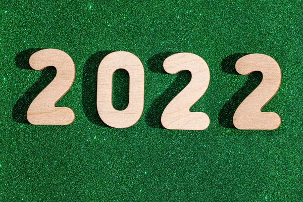 Números de madeira do ano 2022 em um fundo brilhante verde brilhante com pontos amarelos e estrelas. Natal verde — Fotografia de Stock