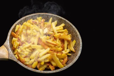 Lezzetli, çıtır çıtır, kızarmış patates dilimleri eski metal kızartma tavasında. Taze pişmiş patates buharı