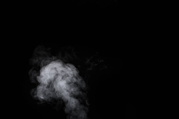 Fragment of white hot curly steam smoke isolated on a black background, close-up. Create mystical Halloween photos. Abstract background, design element