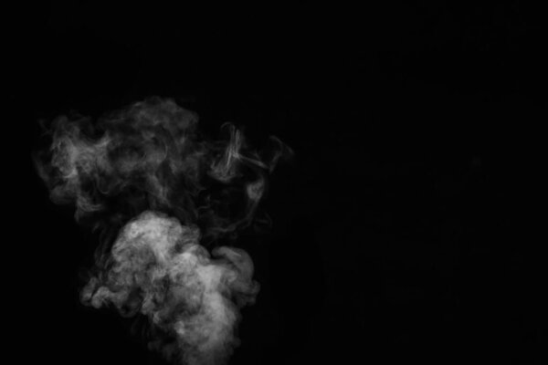 Close up of steam smoke on black background. White hot curly steam smoke isolated on black background, close-up. Create mystical Halloween photos. Abstract background, design element