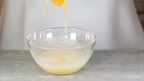 Cozinhar a massa. Mão derramando mel de uma colher de medição em um copo de vidro transparente com uma peça de massa — Vídeo de Stock