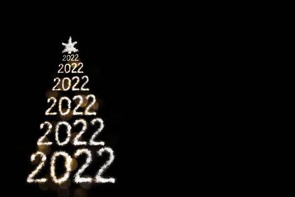 Feliz Ano Novo 2022. Árvore de Natal com neve criativa dos números 2022 e estrela isolada no fundo preto — Fotografia de Stock