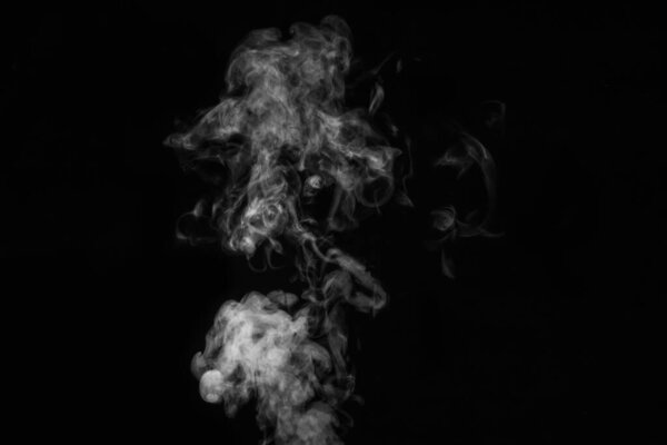 Fragment of white hot curly steam smoke isolated on a black background, close-up. Abstract background, design element.