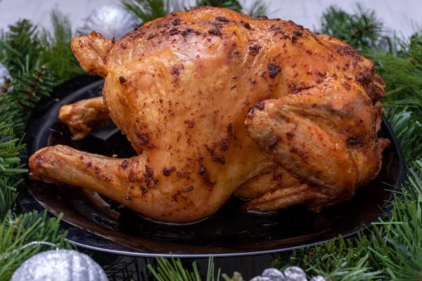 Nourriture traditionnelle de Noël. Poulet frit, dinde sur une table de fête avec branches de sapin et décorations d'arbres de Noël — Photo