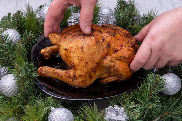 Nourriture traditionnelle de Noël. Mains sculptant du poulet cuit au four, de la dinde sur une table festive avec des branches d'épinette et des décorations de Noël, gros plan. Poulet cuit maison — Photo