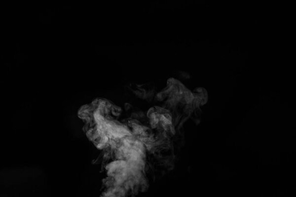 White vapor spray steam from air saturator. Smoke fragments on a black background. Abstract background, design element, for overlay on pictures