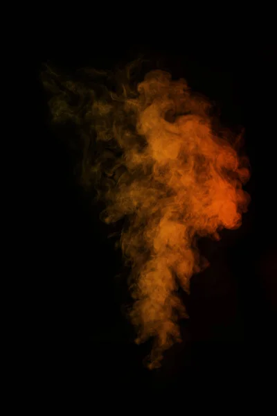 黒の背景に隔離されたオレンジ色の魔法の巻き蒸気煙の断片、クローズアップ。神秘的な写真を作成する. — ストック写真