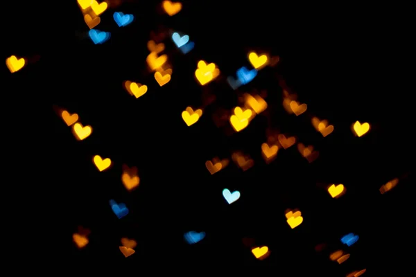 Or jaune et bleu en forme de coeur sur fond noir Bokeh éclairage coloré pour la décoration Valentine, Love Pictures fond — Photo