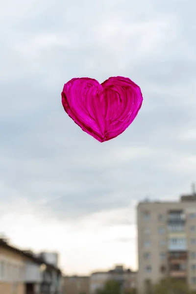 Forma de coração vermelho pintado com tintas no vidro da janela com vista para a rua. Conceito do dia dos namorados. Conceito de amor e relacionamento. Conceito de saúde — Fotografia de Stock