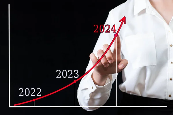 Бизнесмен кладет руку на стрелочный график с высокими темпами роста в 2024 году по сравнению с 2022 и 2023 годами.. — стоковое фото
