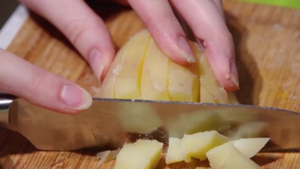 Close-up de um chefe mãos cortando batatas cozidas com uma faca em uma tábua de corte de madeira, hd completo. Processo de cozedura — Vídeo de Stock