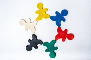 Beyaz arka planda, düz zeminde, üst manzarada izole edilmiş, çok renkli, parlak kil adamlar. Arkadaşlık kavramı, ilişkiler.