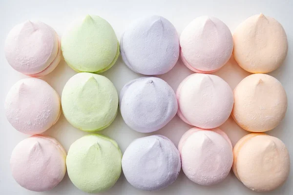 Delicato modello di marshmallow pastello multicolore su uno sfondo chiaro, vista dall'alto, posa piatta. Marshmallow pastello come sfondo. Dolci e cibo sfondo — Foto Stock