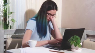 Mavi saçlı gözlüklü yorgun kız dizüstü bilgisayarda yazı yazıyor, kahve içiyor, esniyor, tam donanımlı. Ev aşırı yüklenmesinden çalışıyor. Geç saatlere kadar çalışıp fazla mesai yapıyorum. İş yerinde yanma kavramı