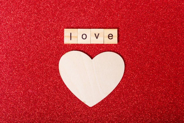 Mot amour sur cubes en bois et forme de coeur en bois sur fond rouge, plat laïc. Amour, romance, concept de relation — Photo