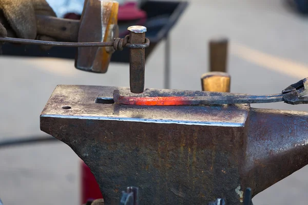 Lavoro del fabbro in un fabbro. La preparazione riscaldata a un ferro di cavallo . — Foto Stock