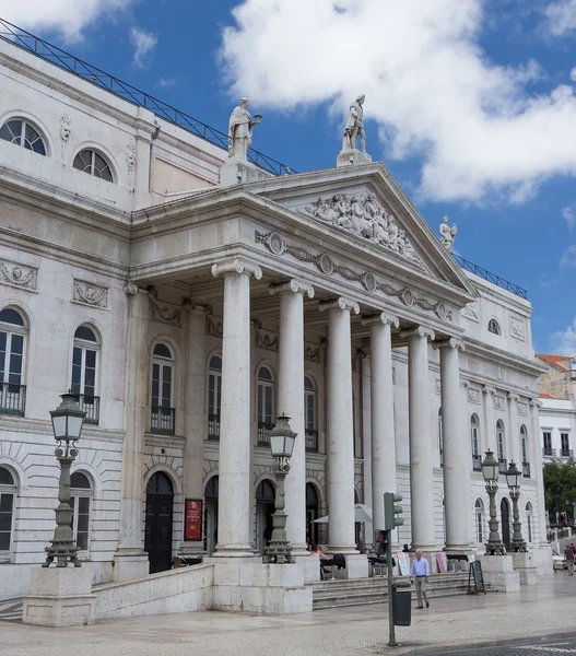 The building with columns and a stucco molding on the top part of a facade of the building against the sky with clouds in Lisbon, Portugal — Stock Photo, Image