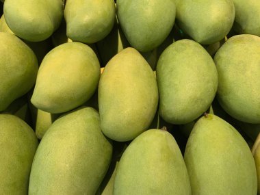 Süpermarketteki taze mangoların en üst görüntüsü. Tayland 'ın yeşil mango geçmişi. Arkaplan için bir sürü yeşil mango.