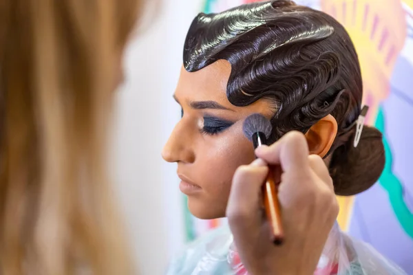 Makeup artist applies blush. Hand of make-up master.  Bright evening makeup.