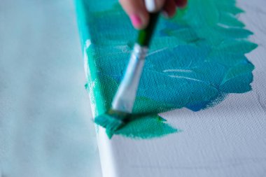 Yeşil ve mavi renklerle boyanmış beyaz tuval. Kapat, seçici odak