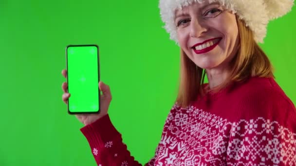 Sonriente hembra muestra teléfono con pantalla verde. — Vídeos de Stock