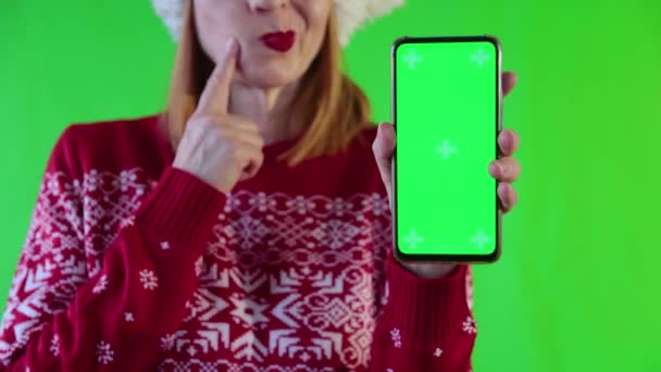 Femme souriante montre téléphone avec écran vert. — Video