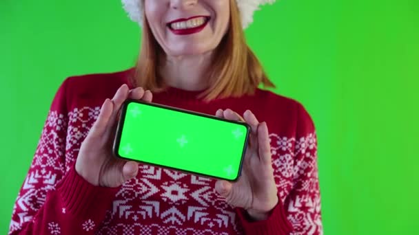 Glimlachende vrouw toont telefoon met groen scherm. — Stockvideo