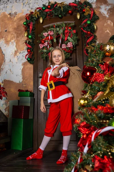 La fille aide Santa aide avec la livraison de cadeaux. — Photo