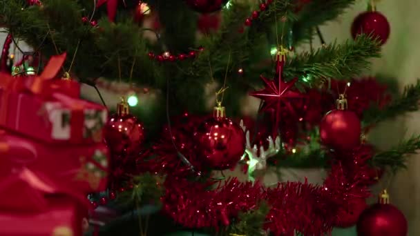 크리스마스 트리는 붉은 공 과깜빡이는 빛으로 장식되어 있습니다. 휴일의 배경 — 비디오