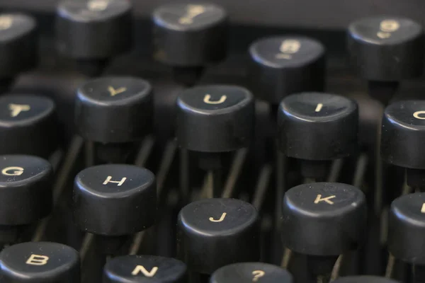 Fechar de um teclado de máquina de escrever preto velho com chaves redondas — Fotografia de Stock