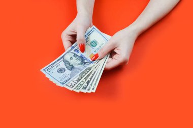 Dolar banknotları kırmızı manikürlü kadın ellerinde.