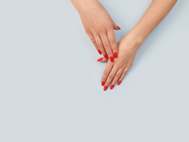 Nemlendirici cilt kremi ya da Kozmetik kremi, mavi masanın üstünde, üzerinde fotokopi alanı olan kadın elleri.