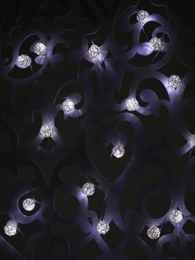 Beyaz rattan topları koyu arkaplanda Noel süsleri. Noel ya da yeni yıl ışıkları desenli duvarlara çelenk astı. Bulanık parlak ampul çelengi. Dikey fotoğraf.