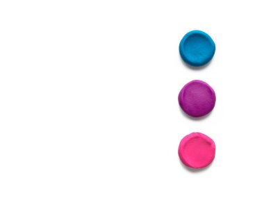 Beyaz arka planda izole edilmiş üç renkli kil plastik parmak desenli düz toplar. Üst görünüm, alanı kopyala.