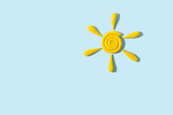 黄色塑料模型粘土手指纹理太阳 阴影隔离在蓝色背景 顶部视图 复制空间 — 图库照片