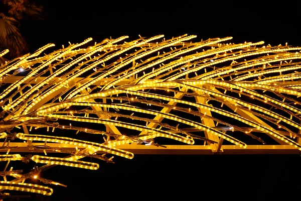 Sokak dekoru, tüy. Led ampullerinin sarı neon ışıklarını ve çelenk ışıklarını yakın çekim. Seçici odak