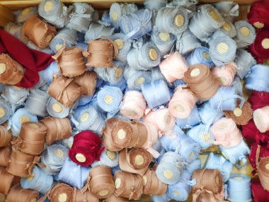 Açık mavi, pembe, bej rengi kahverengi, ahşap makaralı kestane rengi ipek kurdeleler. Doku arka planı. Yakın çekim, üst görünüm.