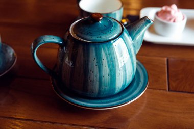 Çayla birlikte mavi seramik çaydanlık. Ön görünüm, seçici odak.