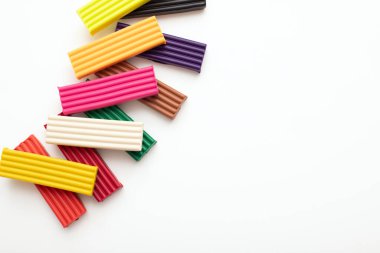Renkli plasticine modelleme kil parçaları veya izole edilmiş beyaz arka planda çubuklar. Üst görünüm, yakın çekim, kopyalama alanı olan çerçeve kenarı.