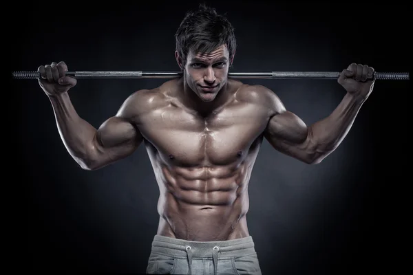 Muskulös bodybuilder killen gör övningar med hantlar över bla — Stockfoto