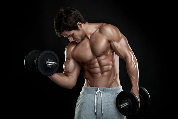 Muscular bodybuilder guy doing exercises with dumbbells over bla — Stock Photo, Image